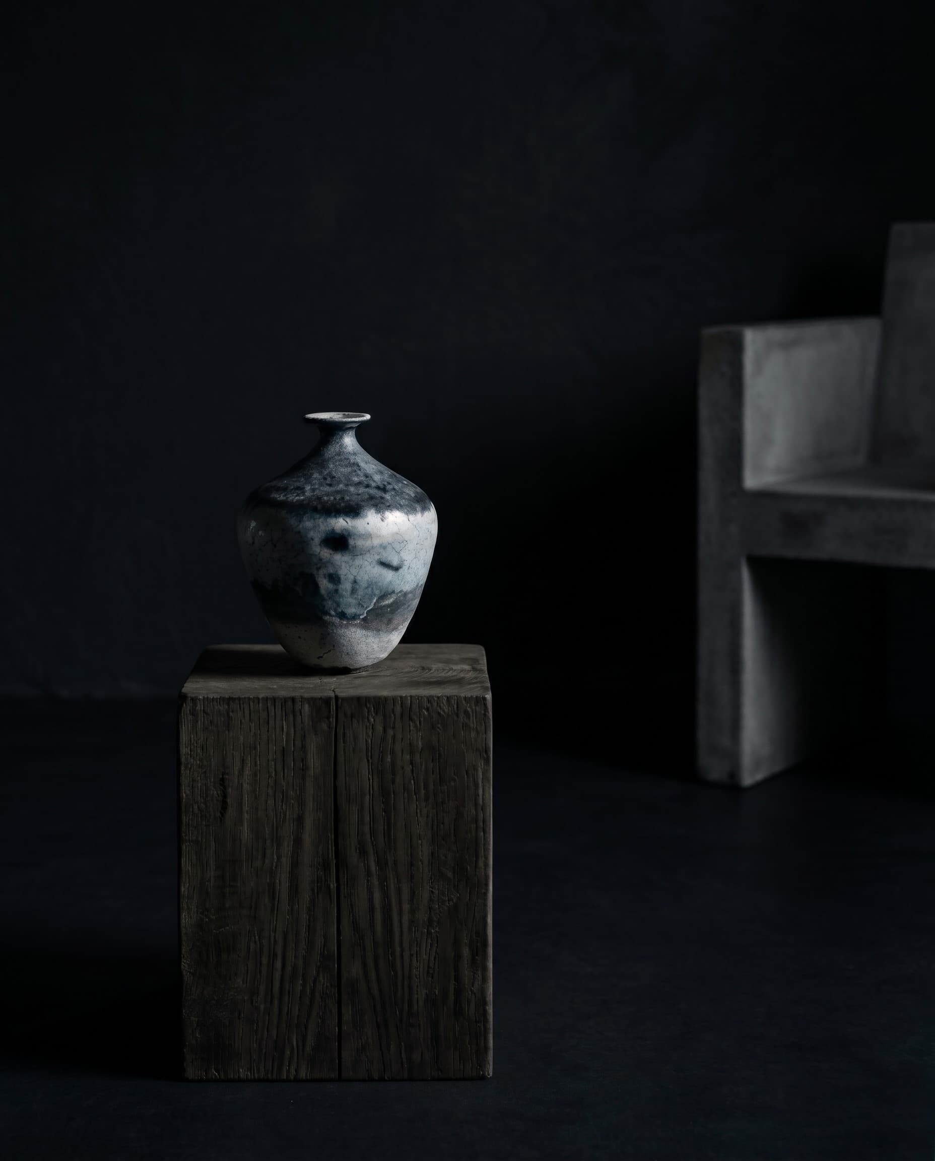 A birch-ash glazed ceramic vase on a dark wooden plinth